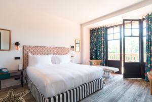 a bedroom with a large bed and a large window at La Guitoune in Pyla-sur-Mer