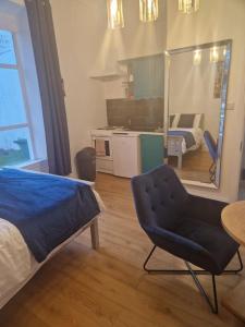 um quarto com uma cama e uma cadeira e uma cozinha em Lovely Studio - perfect weekend stay in Cork em Cork