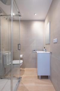 a bathroom with a toilet and a glass shower at LU&CIA Málaga Skyline in Málaga