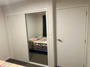 a closet with a mirror and a bed in a room at Private Double Room in Christchurch