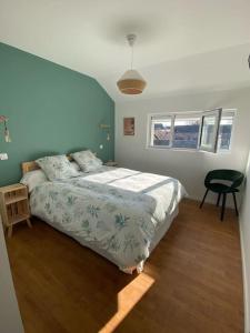 a bedroom with a bed and a chair in it at Maison 2 piscines int/ext, spa in Gueugnon