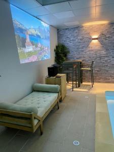 a room with a couch and a table and a painting at Maison 2 piscines int/ext, spa in Gueugnon