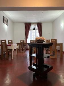 una sala da pranzo con tavolo e ciotola di Princess Bungalows a Nuwara Eliya