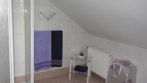een badkamer met een paarse handdoek en een glazen tafel bij Ferienwohnung Am Fenn in Potsdam