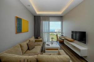 a living room with a couch and a tv at The Stay Furnished Apartments in Dbayeh