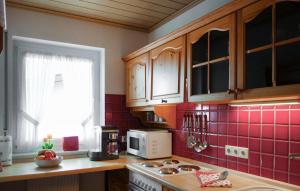 a kitchen with red tile on the wall at Stunning Apartment In Winterberg in Winterberg