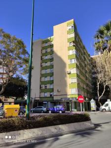 un edificio alto con auto parcheggiate in un parcheggio di Apartamento Velázquez a Málaga