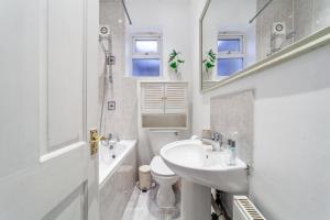 a bathroom with a sink and a toilet and a mirror at The Wood Green Collection in London