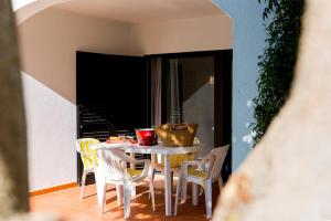 uma mesa com cadeiras e uma tigela em cima em The Albufeira Concierge - Villa Praia São Rafael em Albufeira