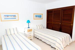 um quarto com 2 camas e uma cómoda com uma mesa de cabeceira em The Albufeira Concierge - Villa Praia São Rafael em Albufeira
