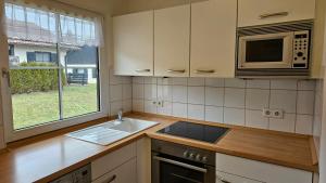 une cuisine avec un évier et un micro-ondes dans l'établissement Lechbruck am See Feriendorf Hochbergle Haus 43, à Lechbruck am See 21 autres photos