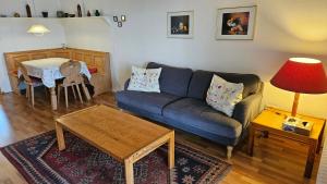 un salon avec un canapé bleu et une table dans l'établissement Lechbruck am See Feriendorf Hochbergle Haus 43, à Lechbruck am See