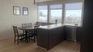 eine Küche und ein Esszimmer mit einem Tisch und Stühlen in der Unterkunft Fossar Villa in Kirkjubæjarklaustur