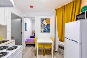 eine kleine Küche mit einem weißen Tisch und gelben Stühlen in der Unterkunft Peaceful Apartment in Lower Manhattan New York in New York