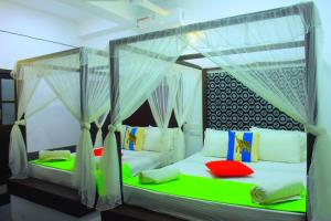 een slaapkamer met twee bedden met klamboes bij Queens Hotel in Udawalawe +15 foto's