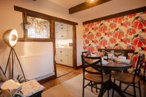 a kitchen with a table and chairs in a room at Charming 2-Bed Cottage in Mickle Trafford- Sleeps 6 - Pet Friendly - Near Chester 