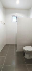 een witte badkamer met een toilet en een raam bij Chiang Khan Dwelling in Chiang Khan