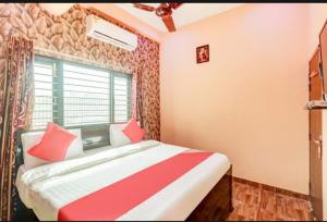 a bedroom with a bed with red and white sheets at Shri Radhe Krishna Bhawan in Lucknow