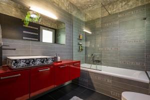 a bathroom with red cabinets and a tub and a sink at Morita Luxury Apartment in Heraklio
