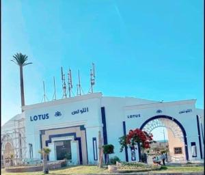 um edifício com uma palmeira em frente em شالية قرية اللوتس em El Alamein
