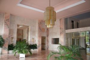 eine Lobby mit Palmen und einem Kronleuchter in der Unterkunft Hermite au Touquet in Le Touquet-Paris-Plage