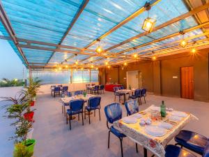 un restaurante con mesas y sillas y techo azul en Treebo Trend Pure Earth Stay - Vijay Nagar, en Indore