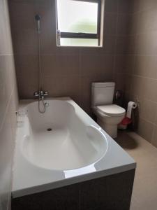 Jwaneng的住宿－Epic Springs Bed & Breakfast，浴室配有白色浴缸和卫生间。