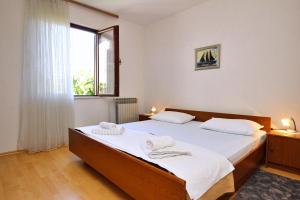 a bedroom with two beds and a large window at Apartments Andela J in Šilo