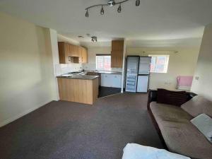 a living room with a couch and a kitchen at 2 bed coach house flat Hereford in Hereford