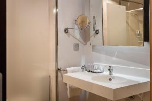 a white bathroom with a sink and a mirror at Hotel Madanis in Barcelona