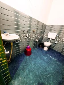 a bathroom with a sink and a toilet at Parinay Vatika Inn in Deoghar