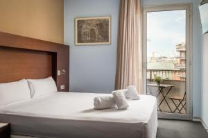a hotel room with a bed and a large window at Hotel Madanis in Barcelona