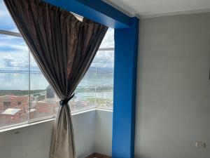 een gordijn in een kamer met een groot raam bij Posada de Percybal Mirador in Puno