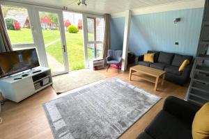 een woonkamer met een bank en een tv bij FRONT LINE Chalet with OPEN Sea Views & Swimming Pool in Kingsdown No14 in Kingsdown