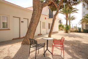 two chairs and a table in front of a tree at Hostal San Juan in El Campello