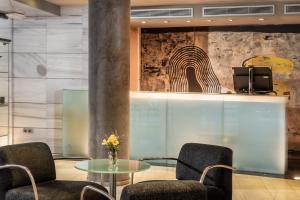 a lobby with two chairs and a glass table at Hotel Madanis in Barcelona