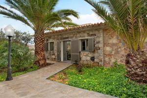 a stone house with a palm tree in front of it at Casa Do Vinho in Porto Santo