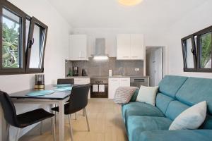 a living room with a blue couch and a table at Casa Do Vinho in Porto Santo