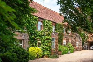 a brick house with ivy growing on it at Ivy Farm 8 in Grimston