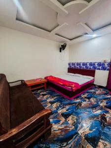 Parinay Vatika Inn في دوغار: غرفة بسرير واريكة على الارض
