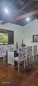 a dining room with chairs and a table and a window at Kerala Guest House Vegan in Caraguatatuba
