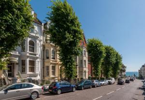 a row of cars parked on a street next to buildings at INNit Bliss in Brighton & Hove