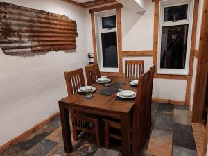 a dining room with a wooden table and chairs at Kempies-Cozy house on the NC500 in Durness