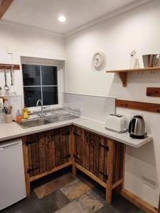 a kitchen with a sink and a counter top at Kempies-Cozy house on the NC500 in Durness