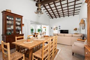 una cucina e una sala da pranzo con tavolo e sedie in legno di Villa Bini Yaya - Cap den Font a Sant Lluís