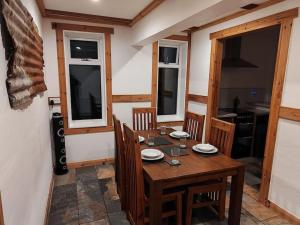 a dining room with a wooden table and chairs at Kempies-Cozy house on the NC500 in Durness