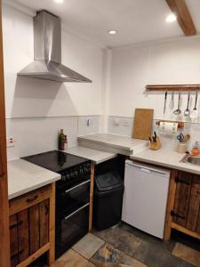 a kitchen with a sink and a stove top oven at Kempies-Cozy house on the NC500 in Durness