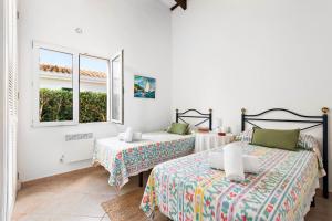 una camera da letto con due letti e una finestra di Villa Bini Yaya - Cap den Font a Sant Lluís Altre 21 foto