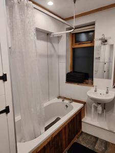 y baño con bañera y lavamanos. en Kempies-Cozy house on the NC500 en Durness