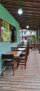 een restaurant met houten tafels en banken op een terras bij Kerala Guest House Vegan in Caraguatatuba